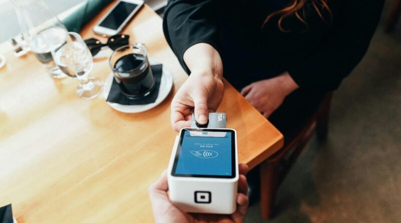 A person using a swipe machine.