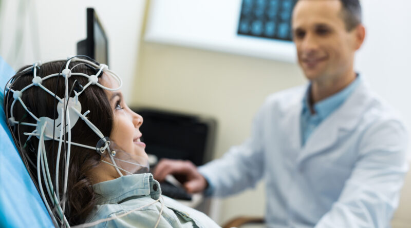 Medical specialist carrying out electroencephalographic diagnostics of patient